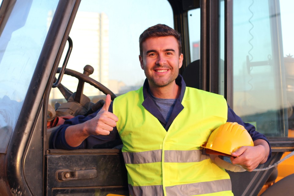 Mann vor Baumaschine