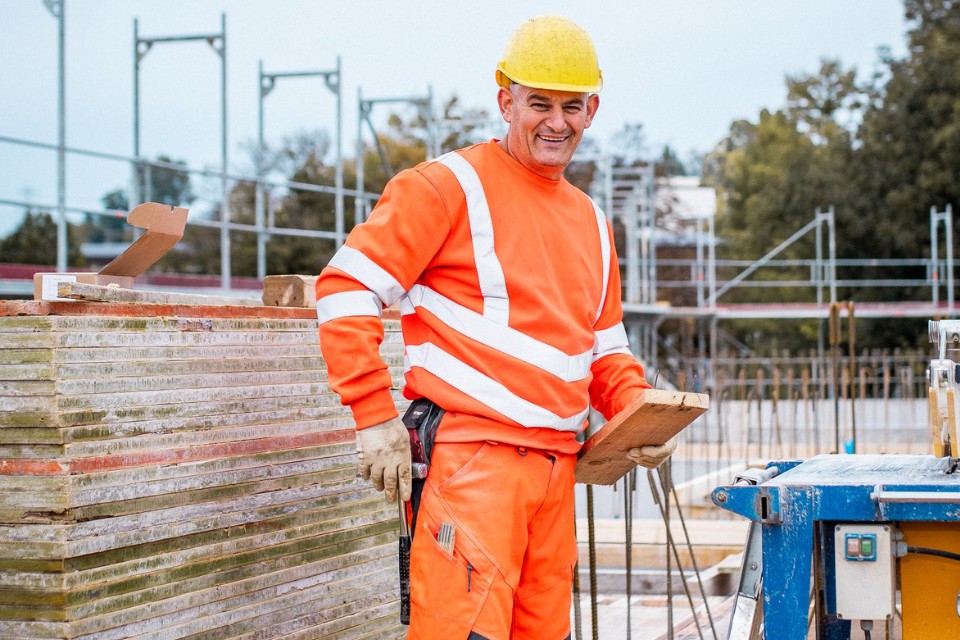 bauarbeiter mit holz in der hand